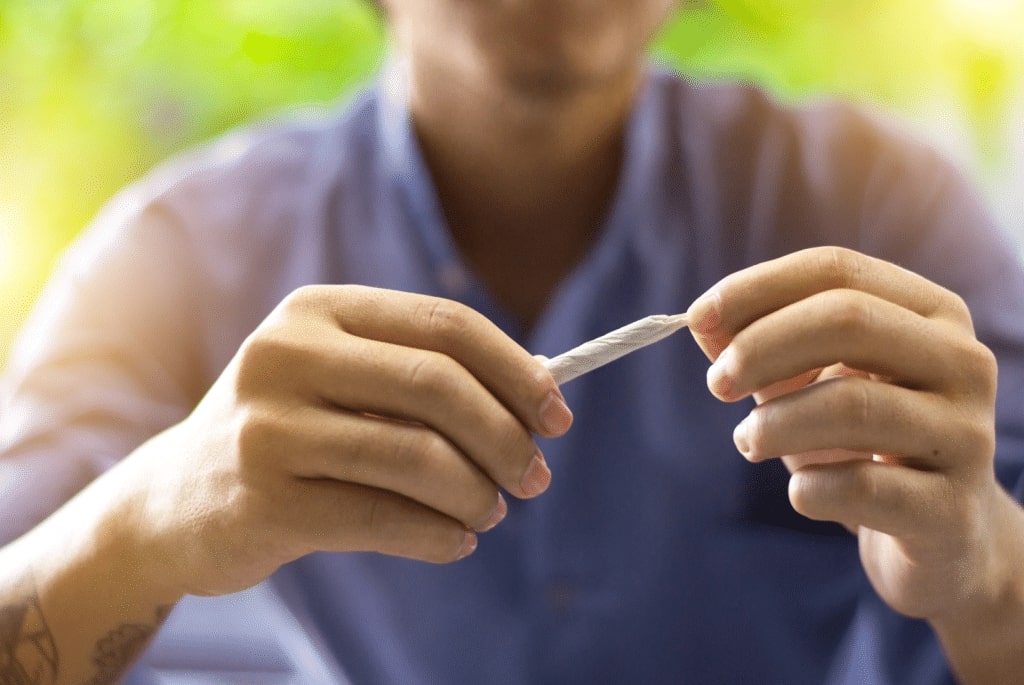 man holding joint in hands outside