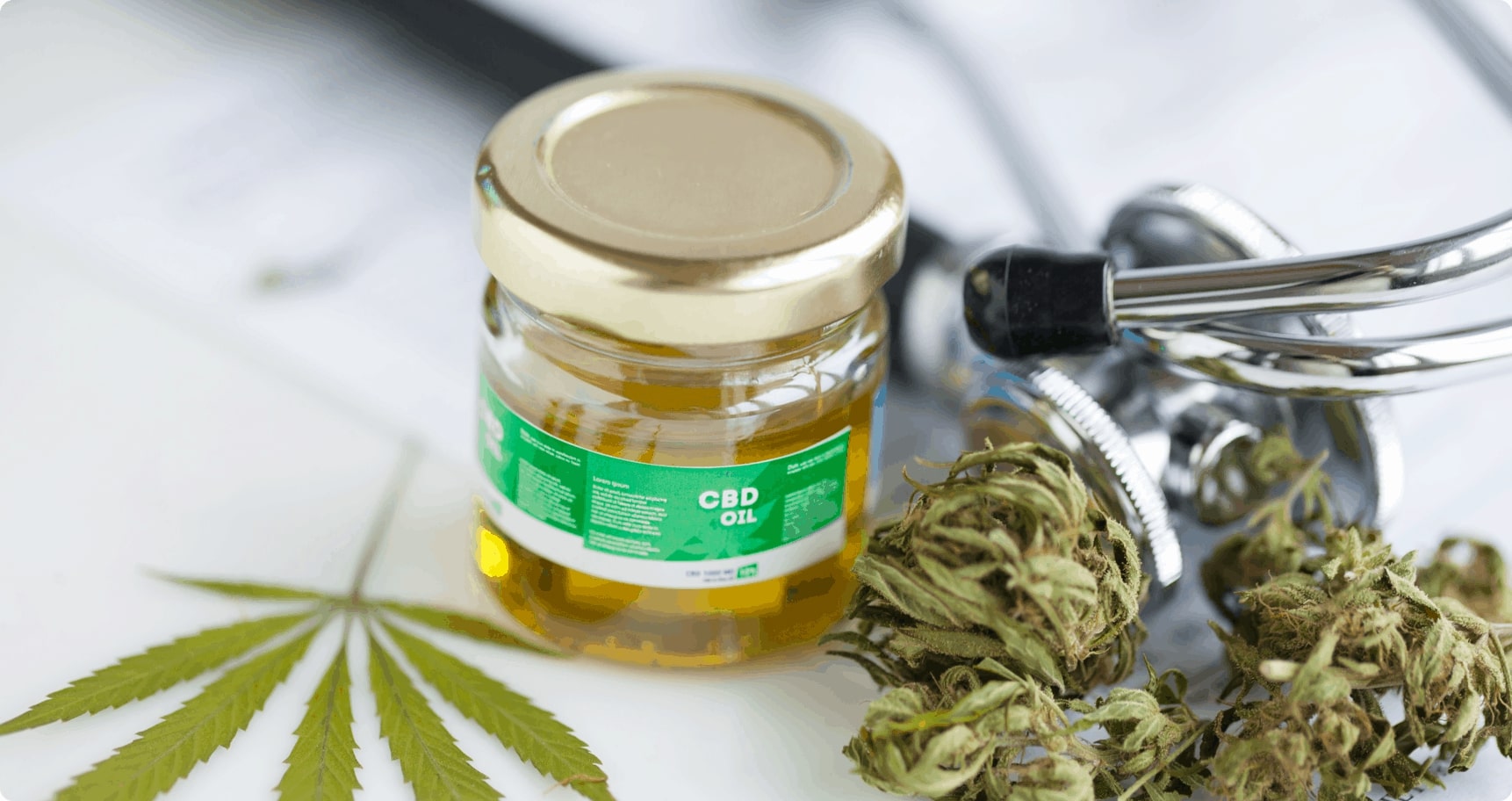 CBD oil next to cannabis leaf and flower