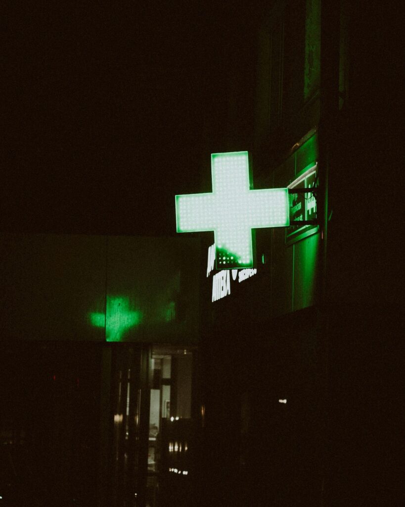 A glowing green sign outside of a medical cannabis dispensary.
